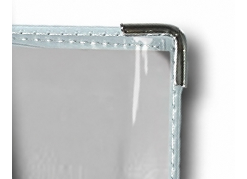 Platinum-colored metal corner on the front of a gray Bible in its stitched vinyl cover