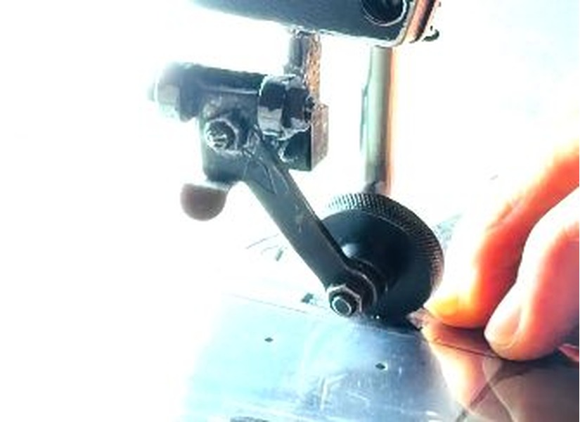 Hands guiding clear vinyl through a sewing machine